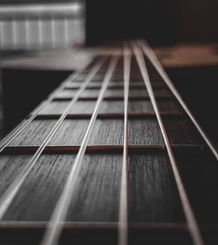Close-up of a guitar fretboard showing strings and frets